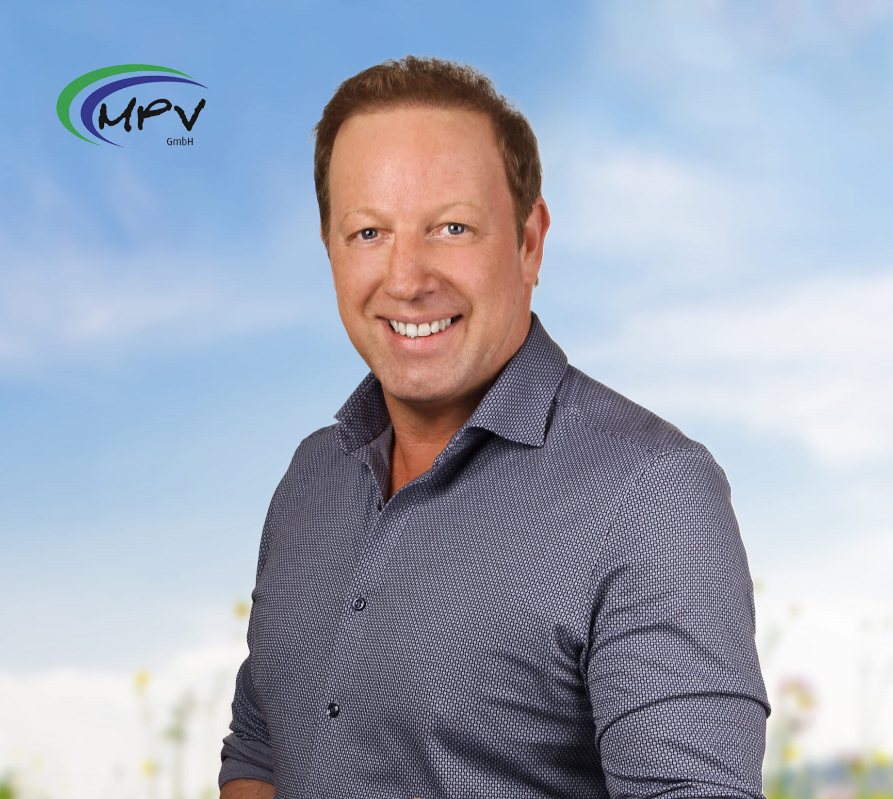 Portrait eines lächelnden Mannes in Business-Kleidung vor einem blauen Himmel, repräsentativ für die MPU Vorbereitung bei der MPV GmbH