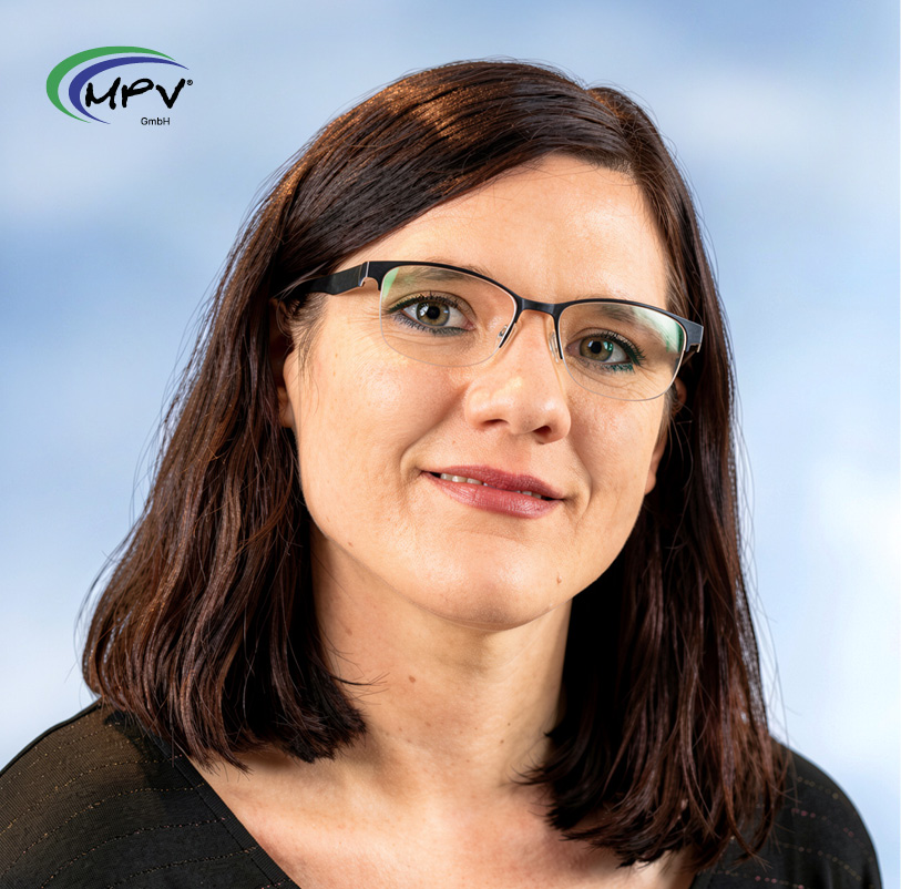 Porträt einer Mitarbeiterin der MPV GmbH mit Brille vor hellem Hintergrund.