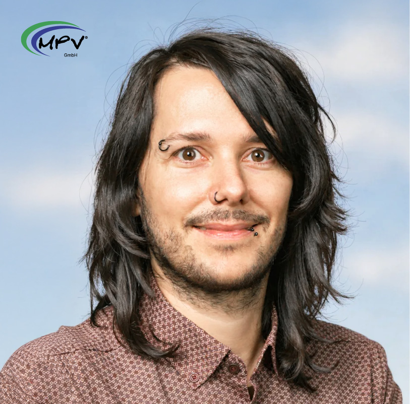 Porträt eines Beraters der MPV GmbH mit Piercings vor hellem Hintergrund.